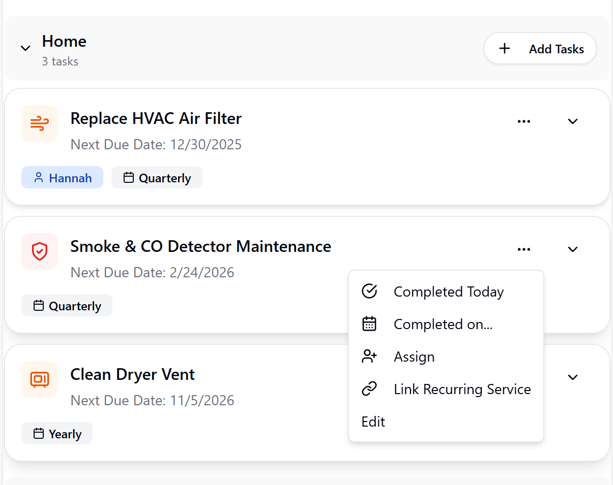 A task management interface for a home maintenance schedule, showing options to mark tasks complete or assign them.